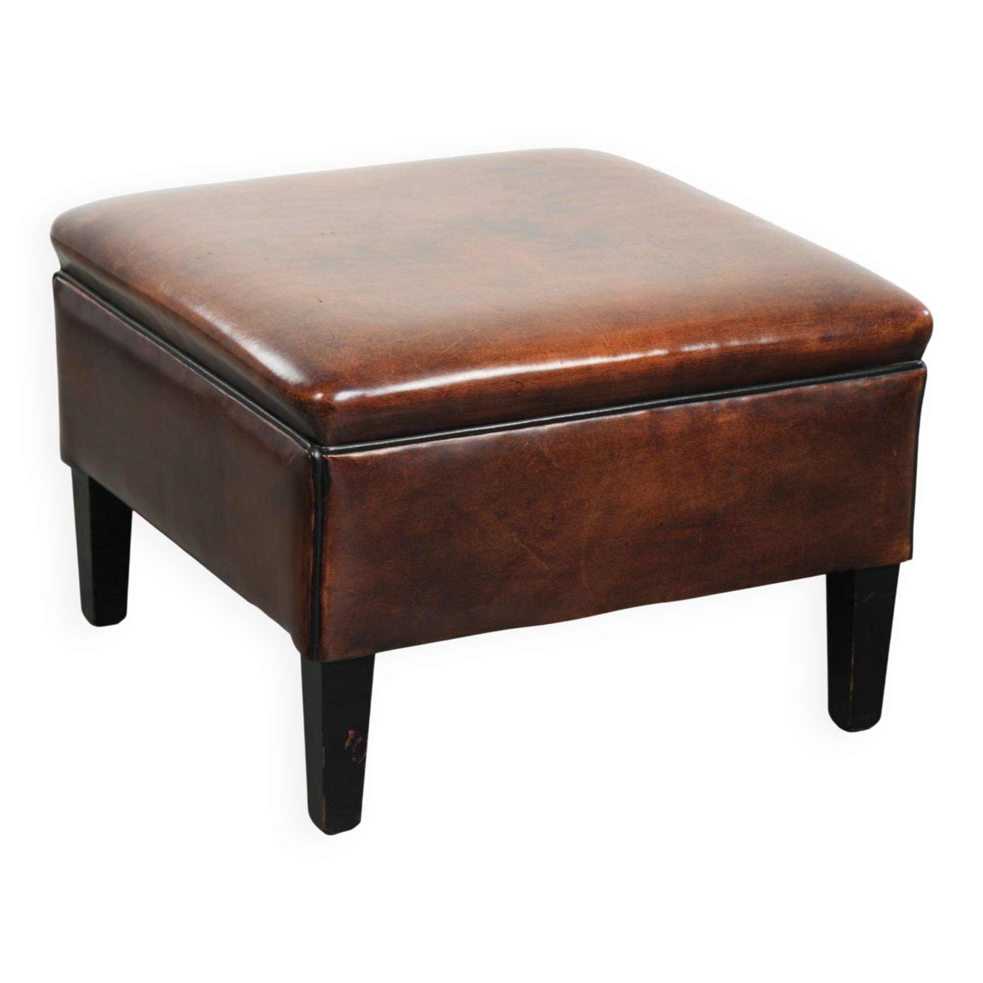 Large dark brown square ottoman made of sheepskin with black piping