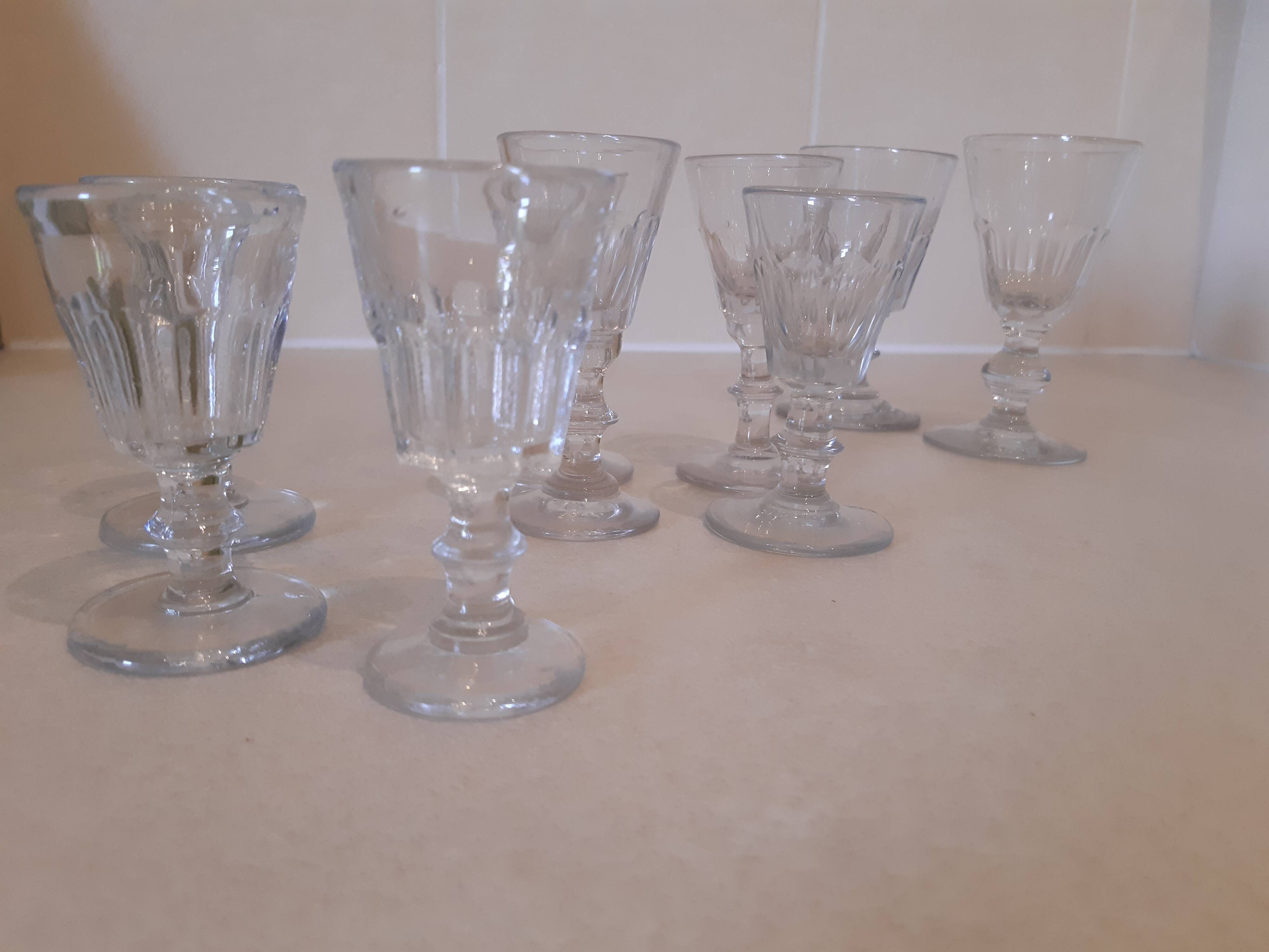 Set of 9 small cut glass stemmed glasses from the 1930s, in various sizes.