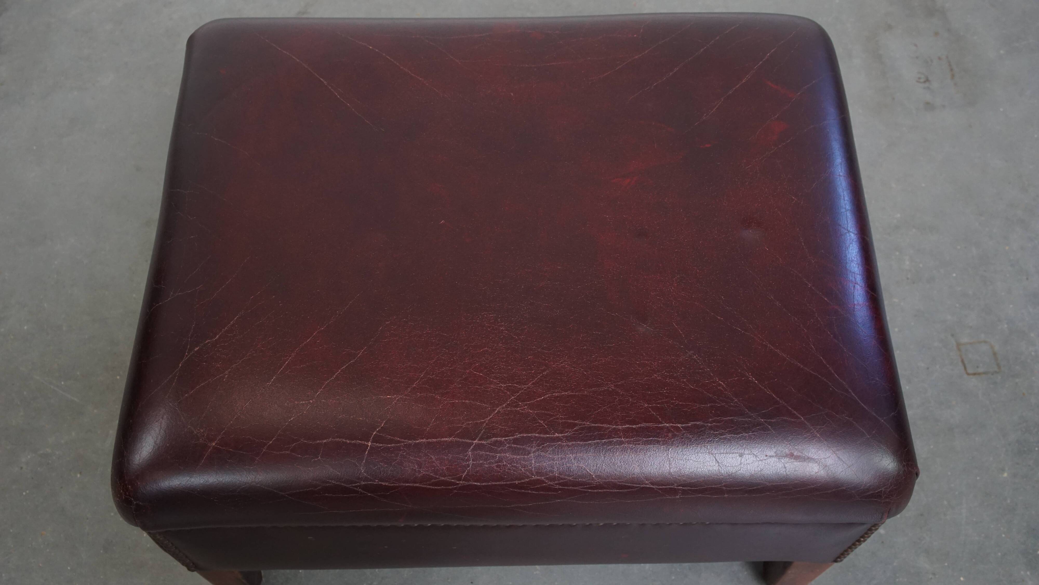Ensemble de 2 fauteuils à oreilles en cuir de vachette + pouf de style anglais