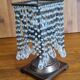 Metal candle holder with white glass tassels