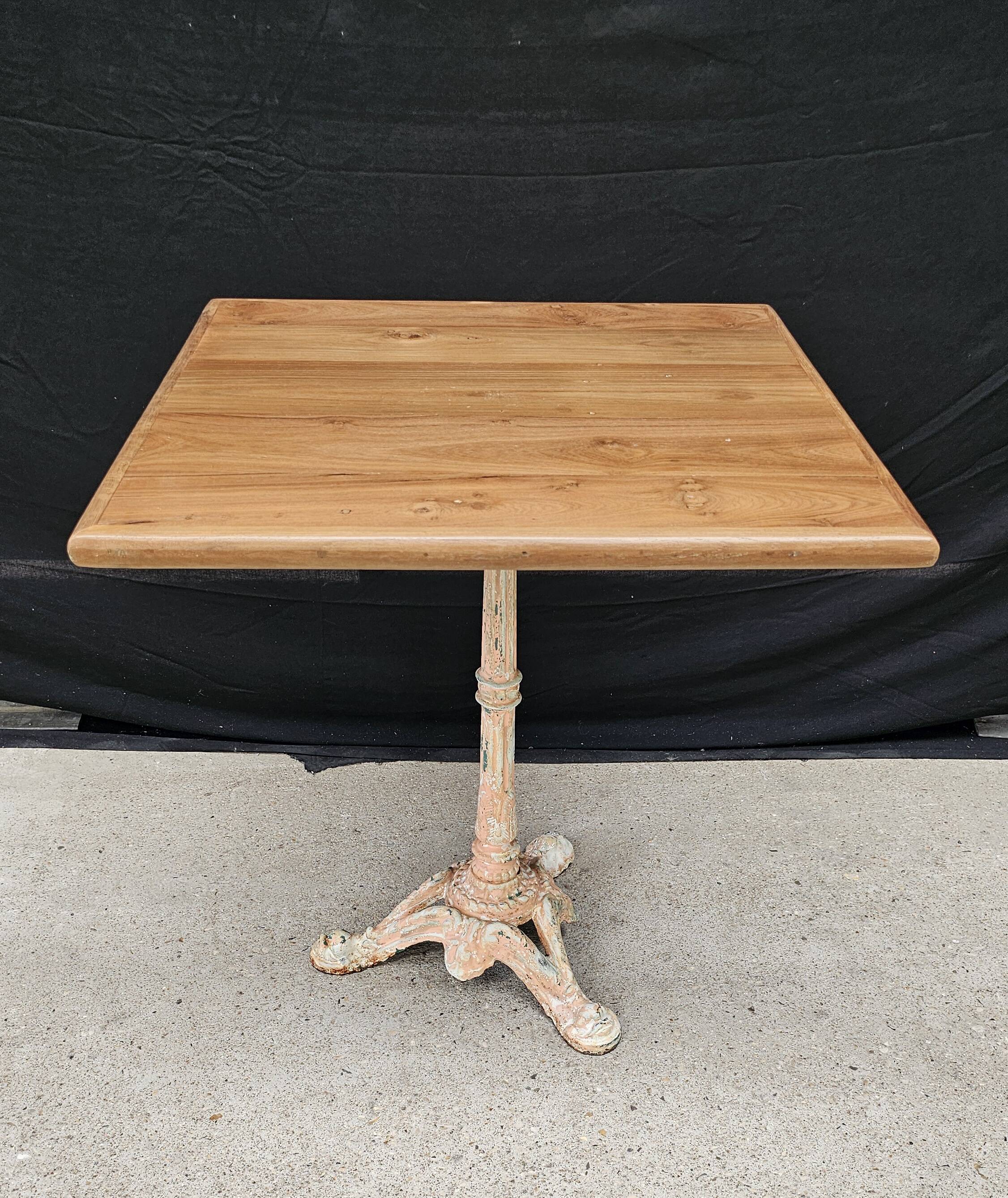 Bistro table with cast iron base and solid teak top