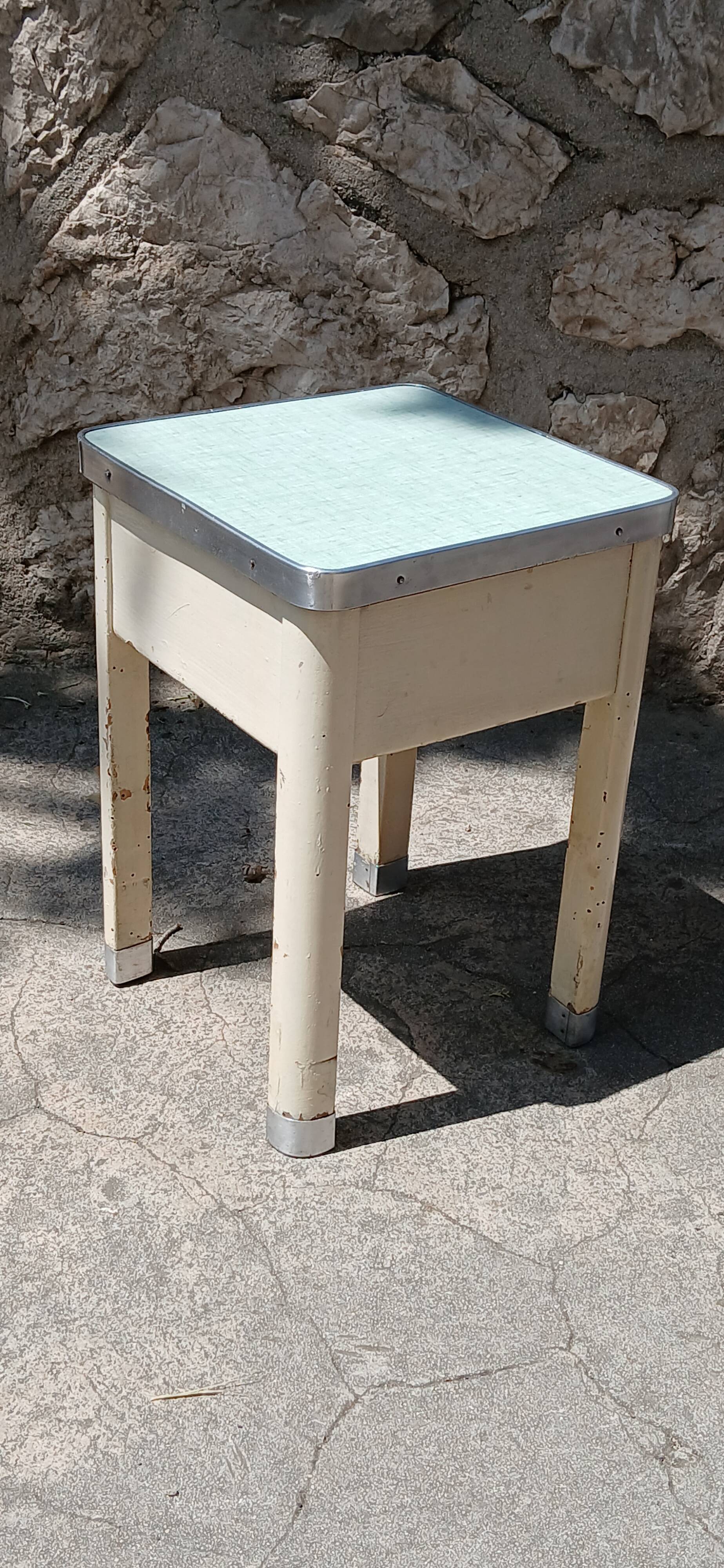 Shoe polish stool with round top and aluminum legs.