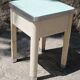 Shoe polish stool with round top and aluminum legs.