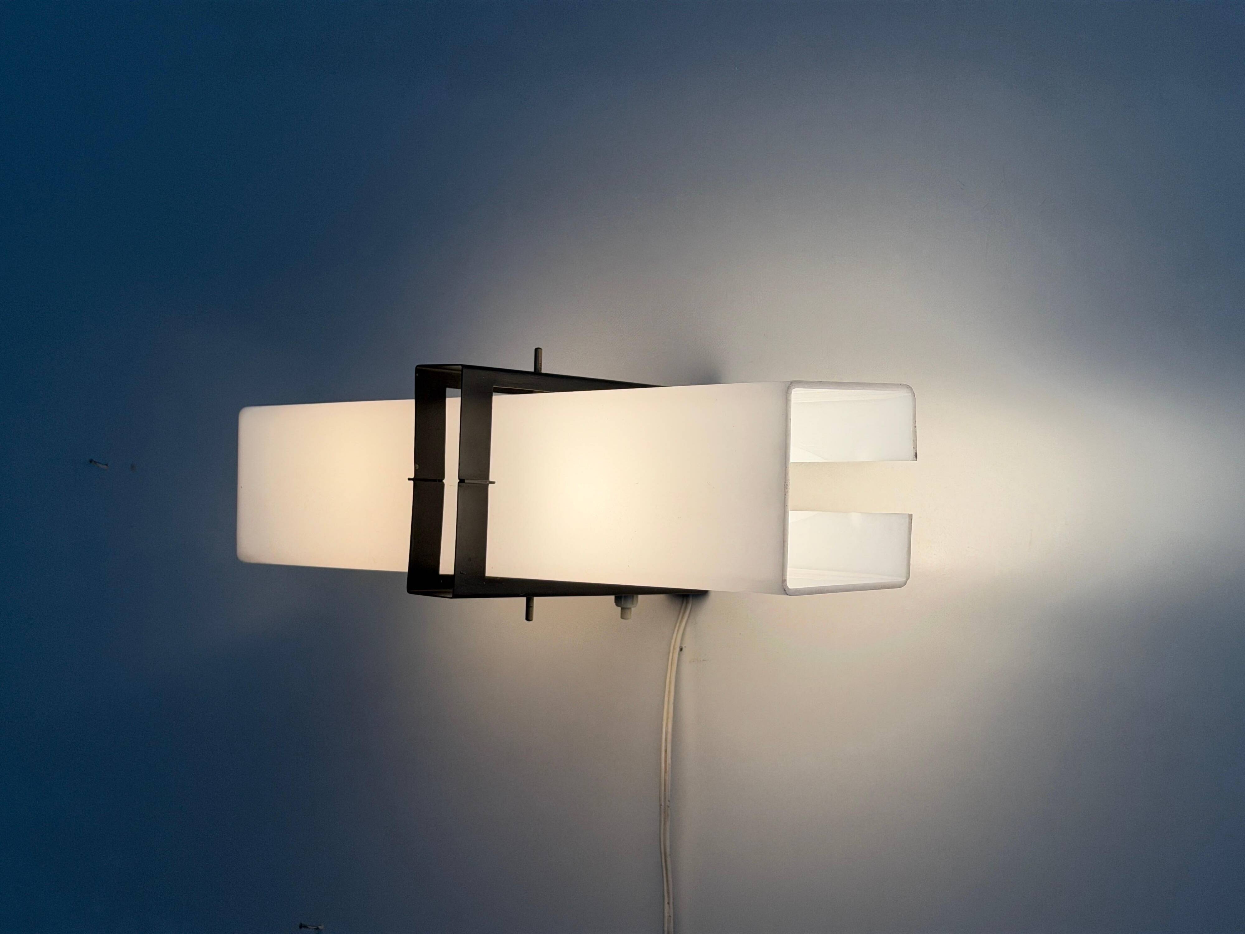 Simple white plexiglass wall light with a black metal frame, 1970s, Germany.