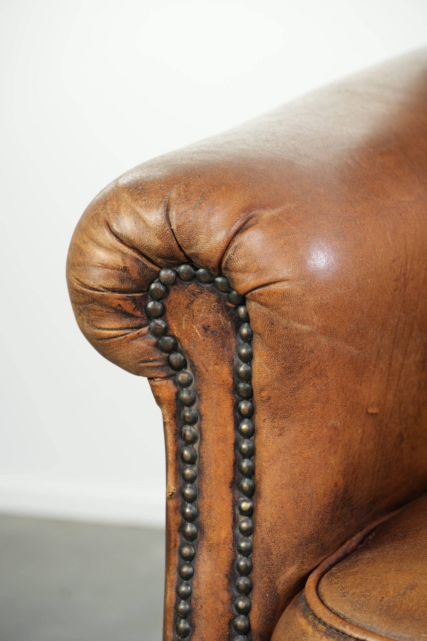 Comfortable characterful sheepskin armchair finished with decorative nails