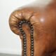Comfortable characterful sheepskin armchair finished with decorative nails