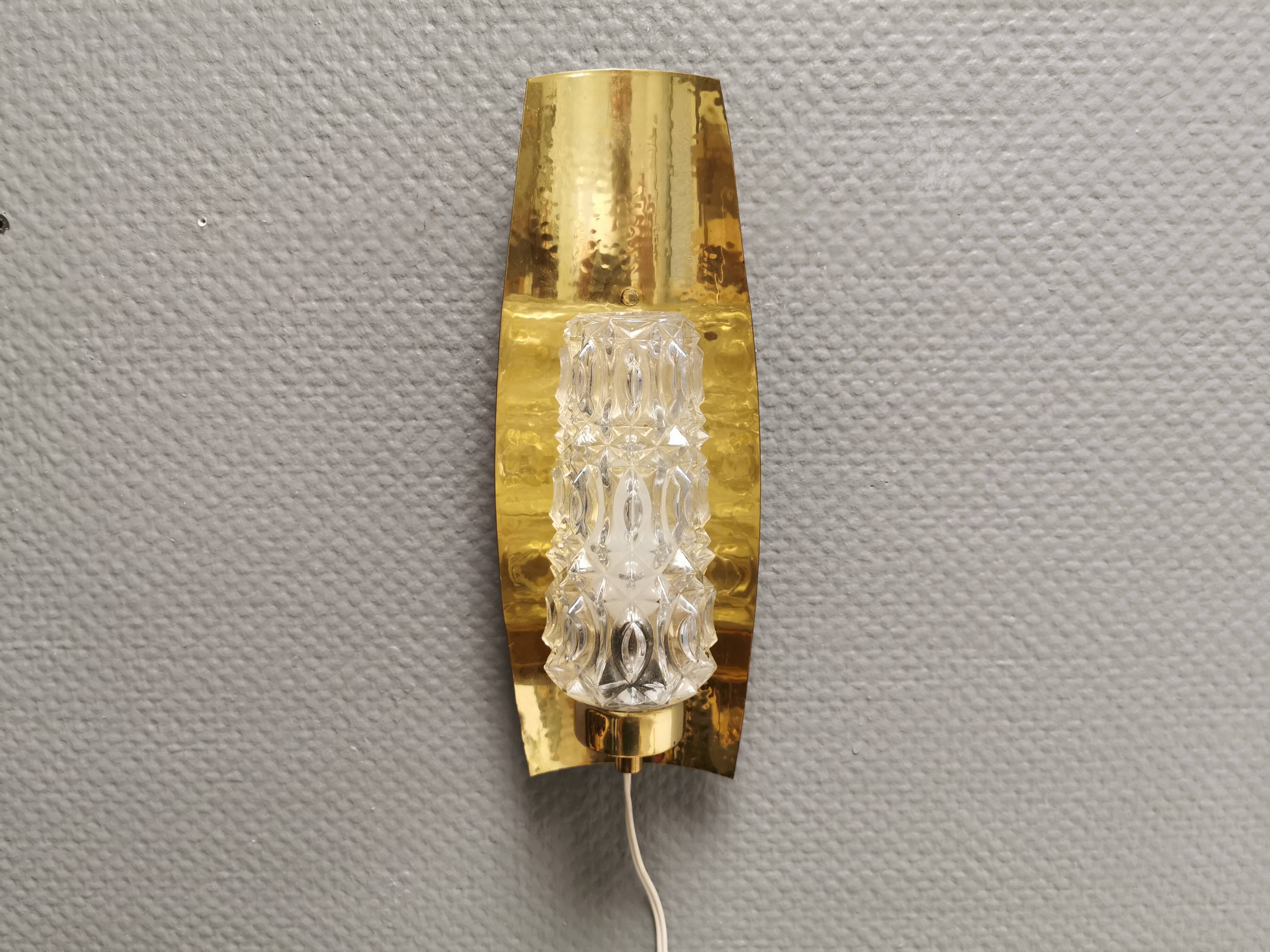 Older wall lamp in brass with hard pressed glass shade.