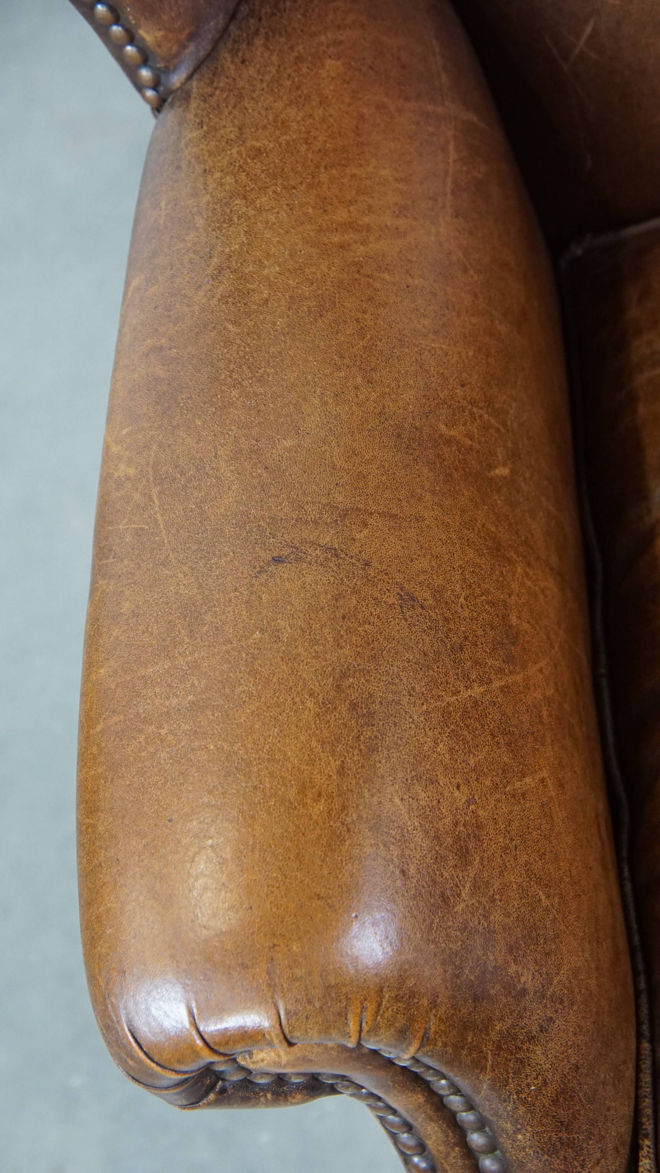 Cognac-colored sheepskin wing chair in English style