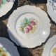 Antique plates from the late 19th century with scalloped edges and fruit decoration.