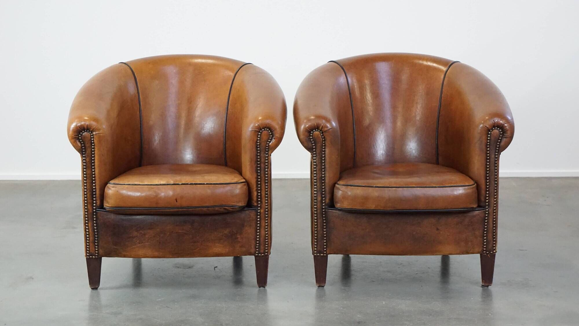 Set of 2 club armchairs in sheepskin leather with black piping