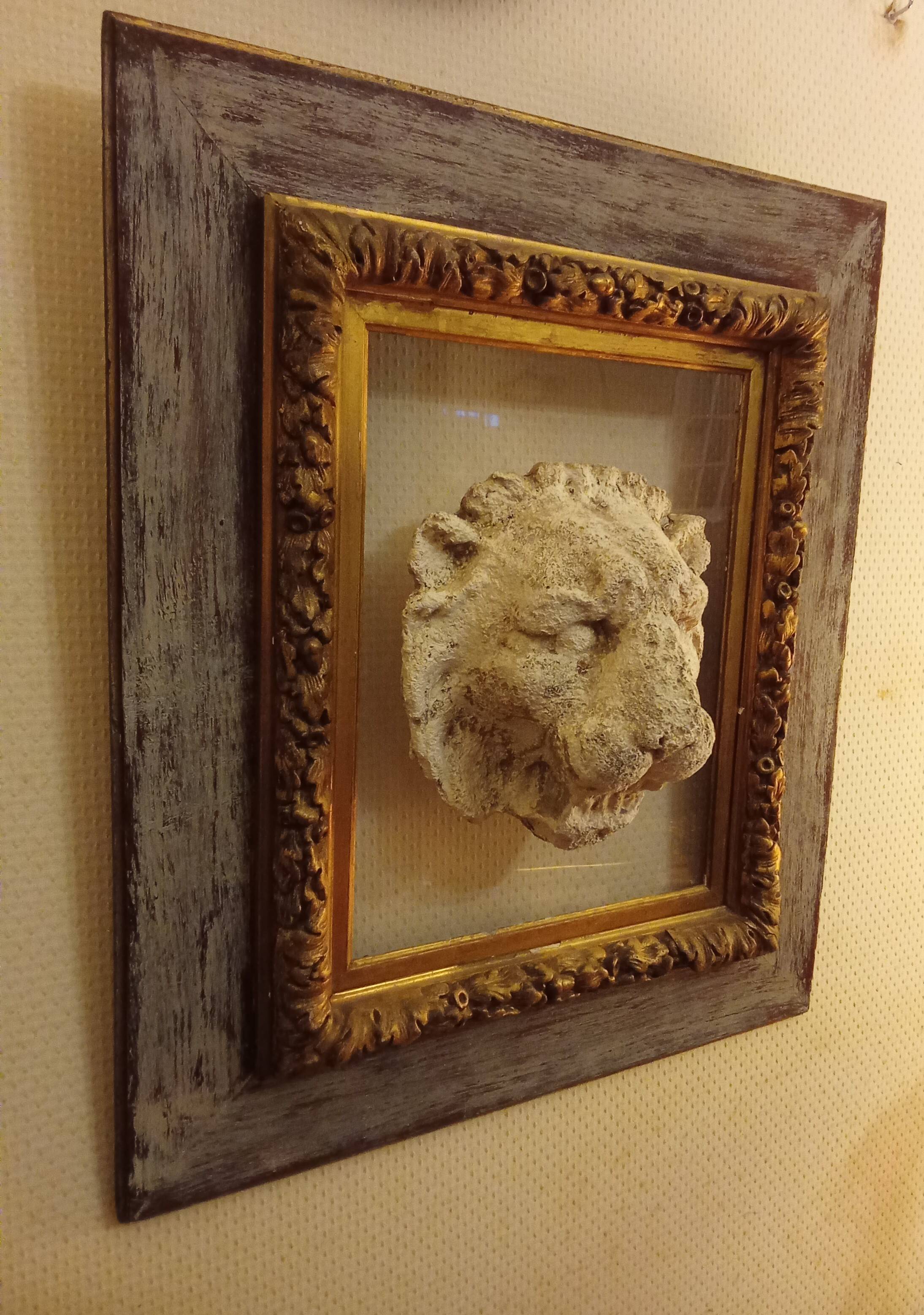 Antique gilded frame with stone lion head ornament on plexiglass