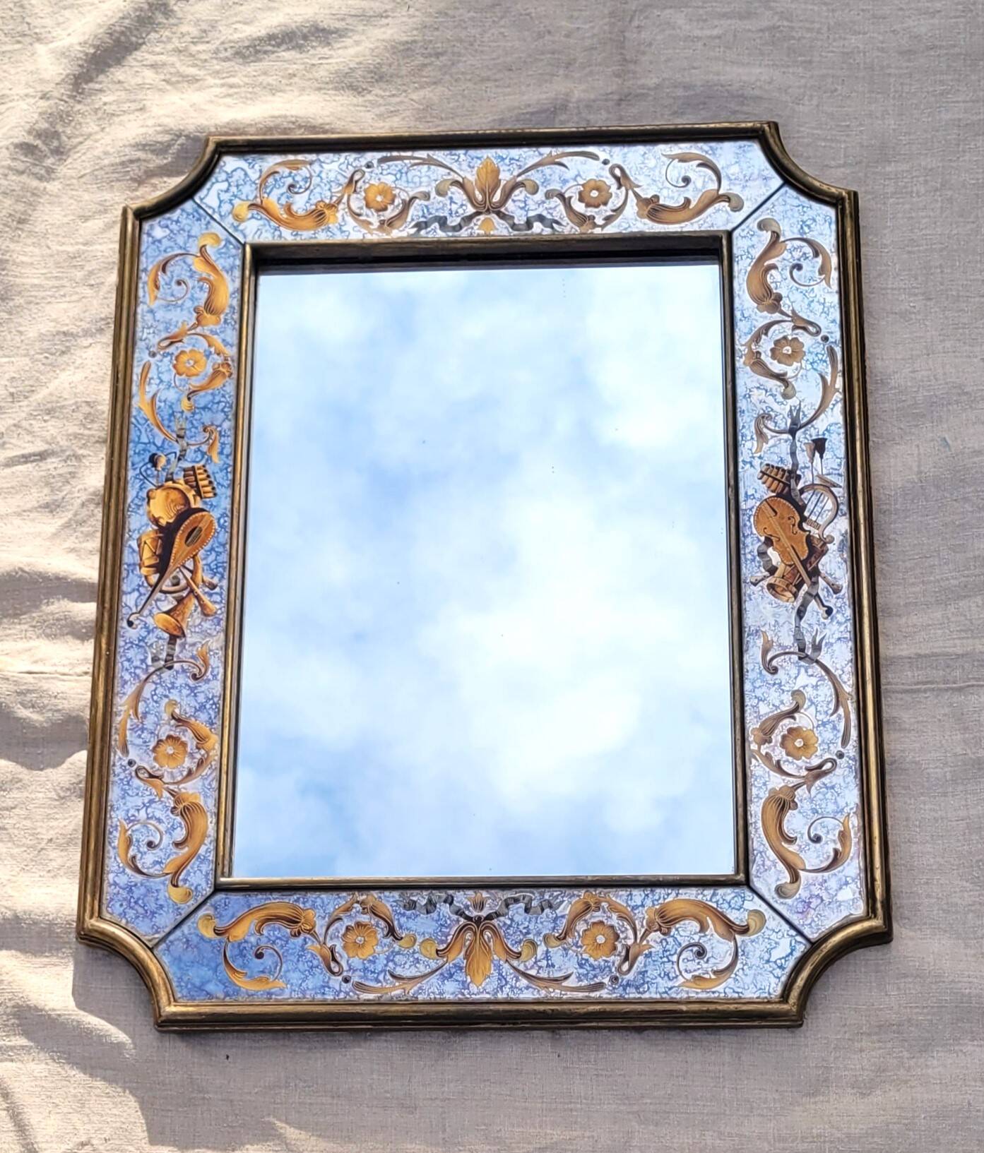 50s Eglomisé glass mirror with musical instrument decor