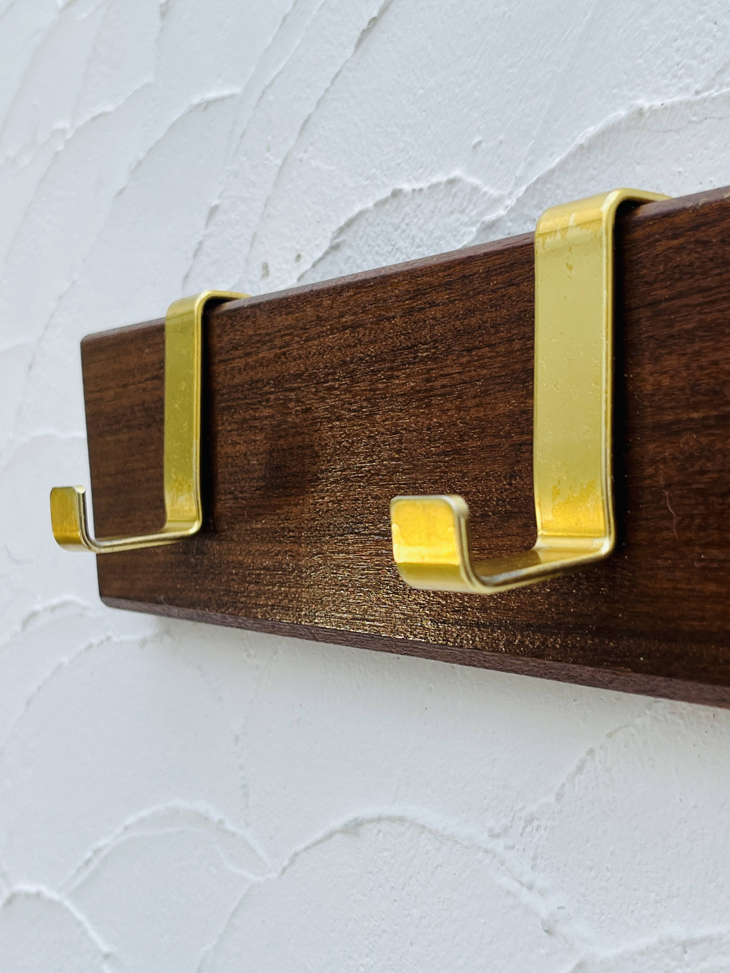 Vintage wooden and brass coat rack with 3 hooks from the 1960s.