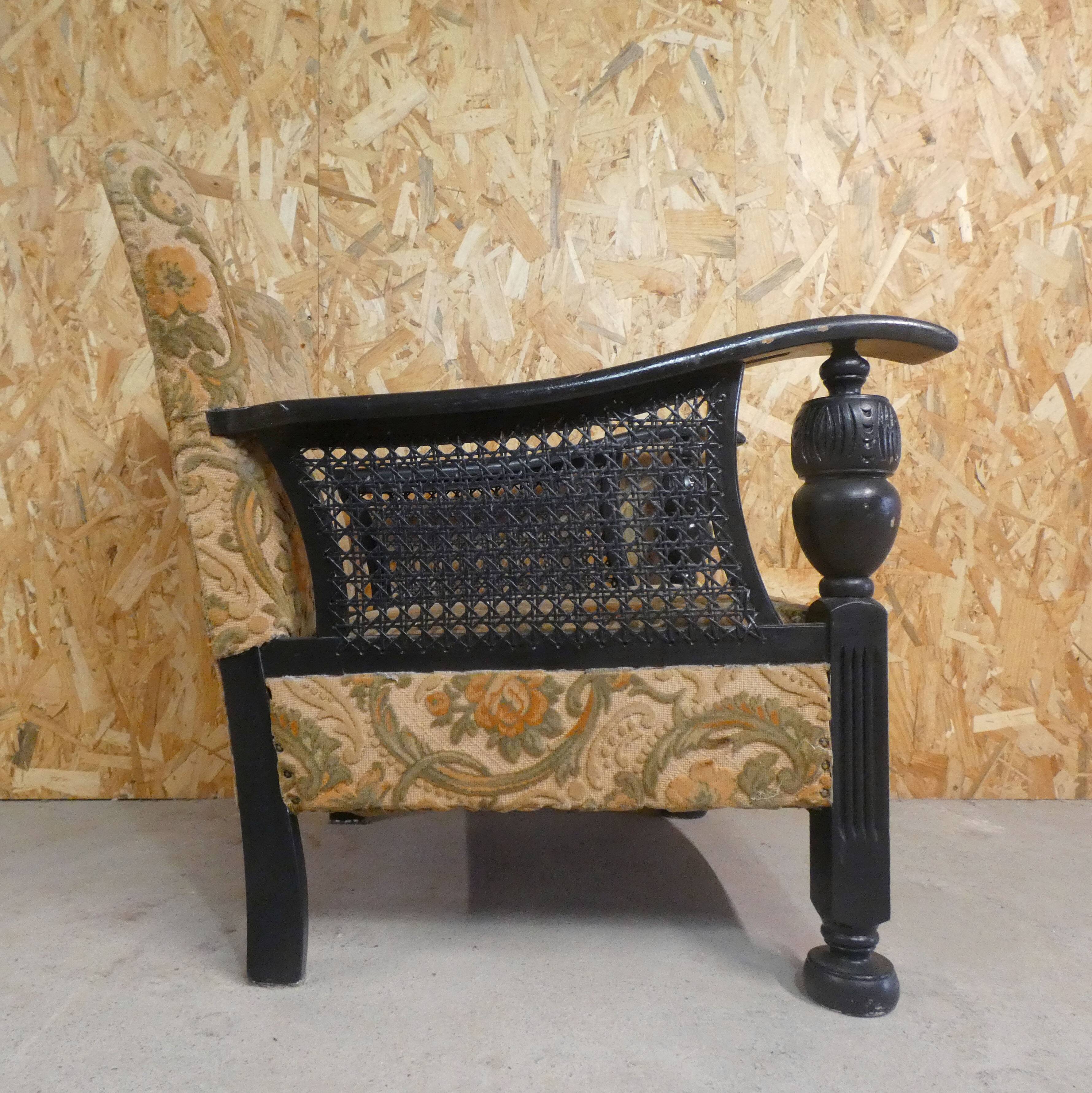 Old armchair upholstered in velvet, carved and caned wood