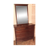 Style set: bevelled mirror and curved wooden chest of drawers.