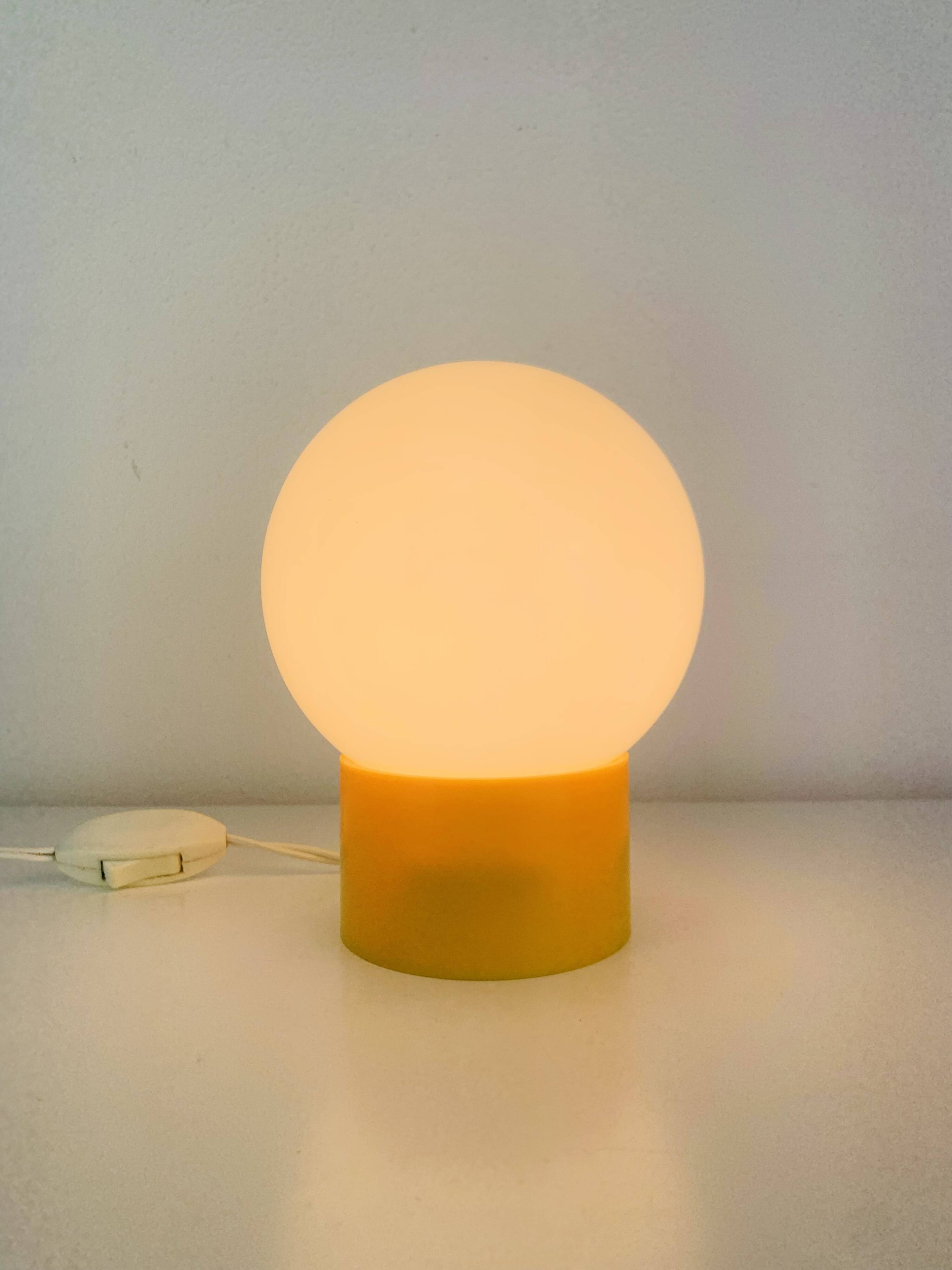 Space Age ball lamp, opaline with a yellow base, 1960s.