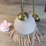 Brass swan neck wall lamp with pink glass globe and Charleston tassels