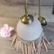 Brass swan neck wall lamp with pink glass globe and Charleston tassels