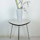 Table basse des années 1950 à trois pieds avec un plateau en formica et des pieds en chrome inclinés.