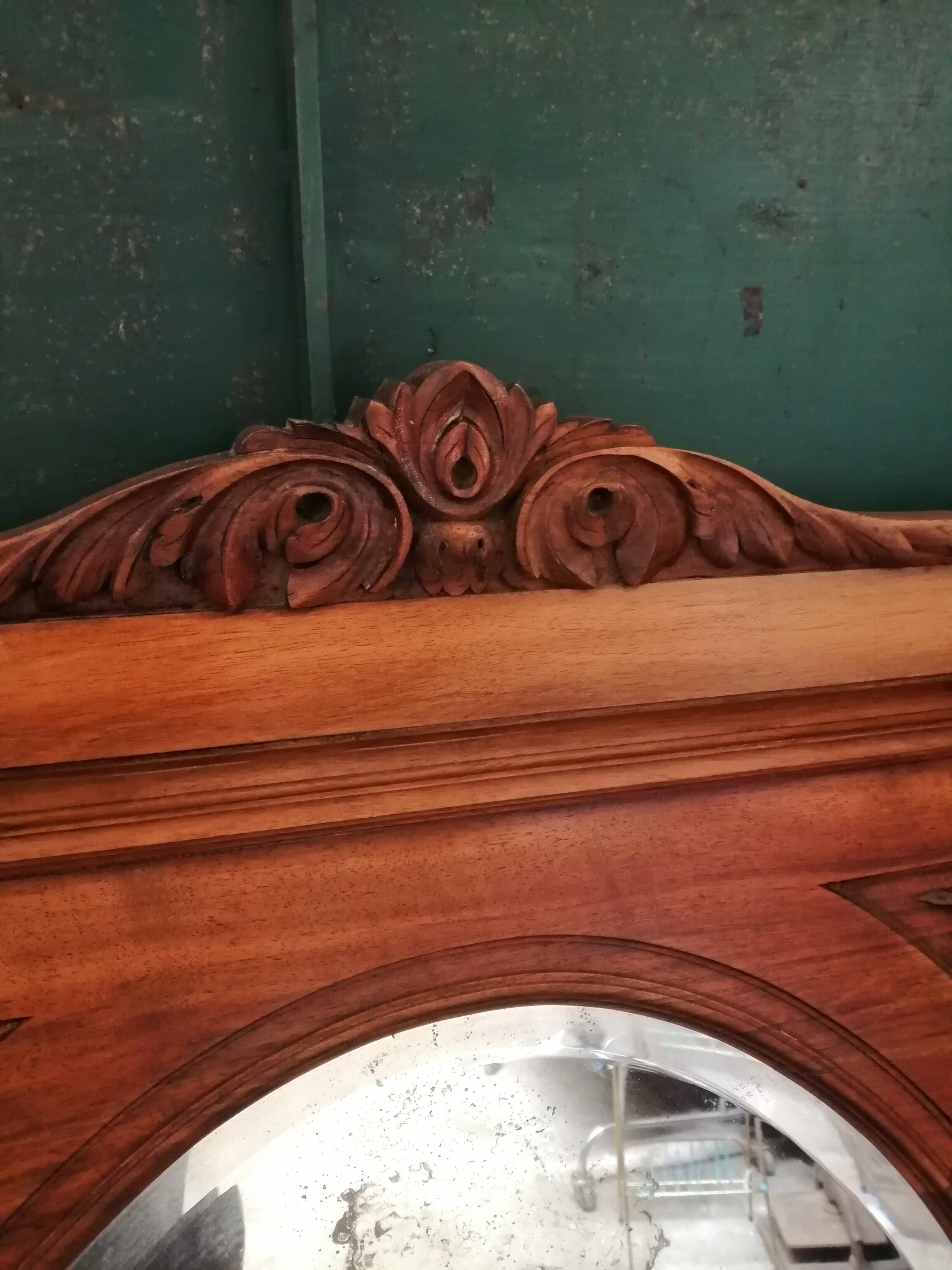 Old oval walnut wood mirror has flower carvings decoration