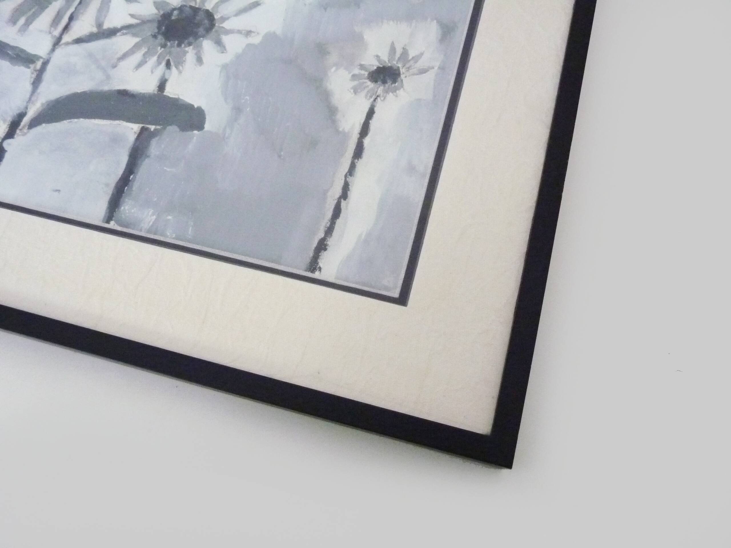 Framed painting with gray flower decor.