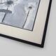Framed painting with gray flower decor.