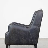 Black cow leather armchair in industrial style finished with decorative nails