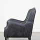 Black cow leather armchair in industrial style finished with decorative nails
