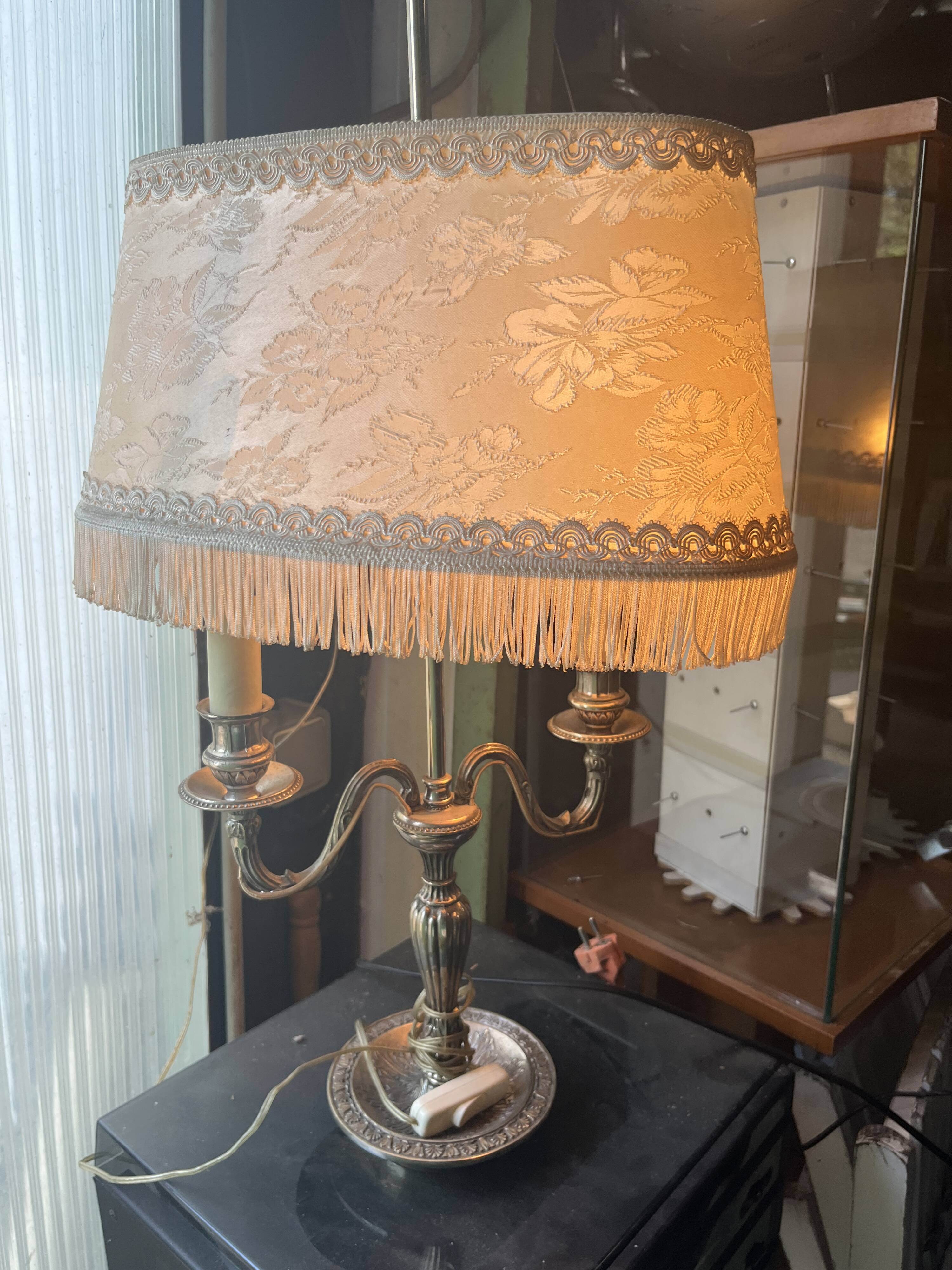 Two-armed hot water bottle lamp in silver metal with fringed fabric shade