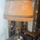 Two-armed hot water bottle lamp in silver metal with fringed fabric shade