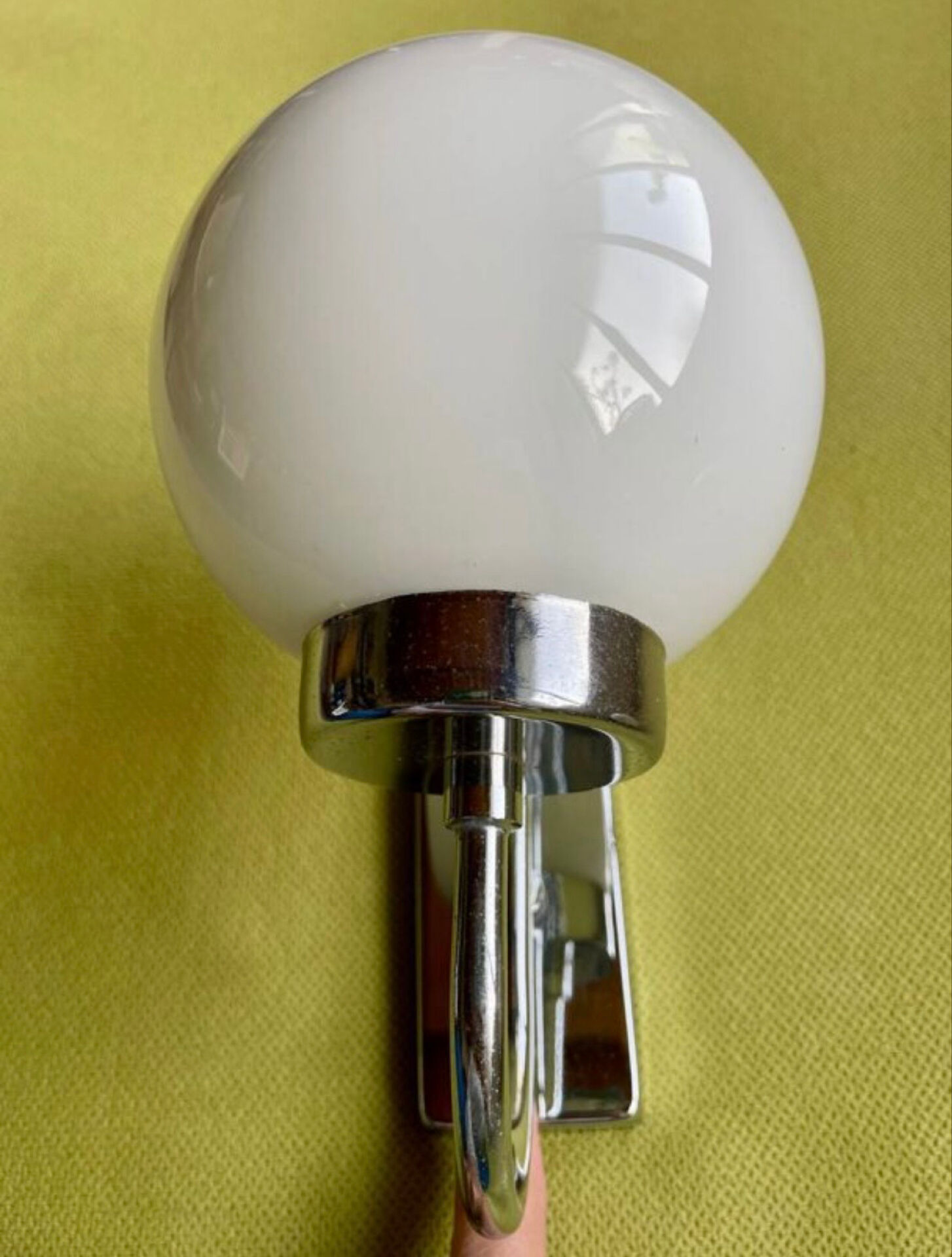 Pair of chrome metal wall lights with white glass globe.