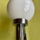 Pair of chrome metal wall lights with white glass globe.