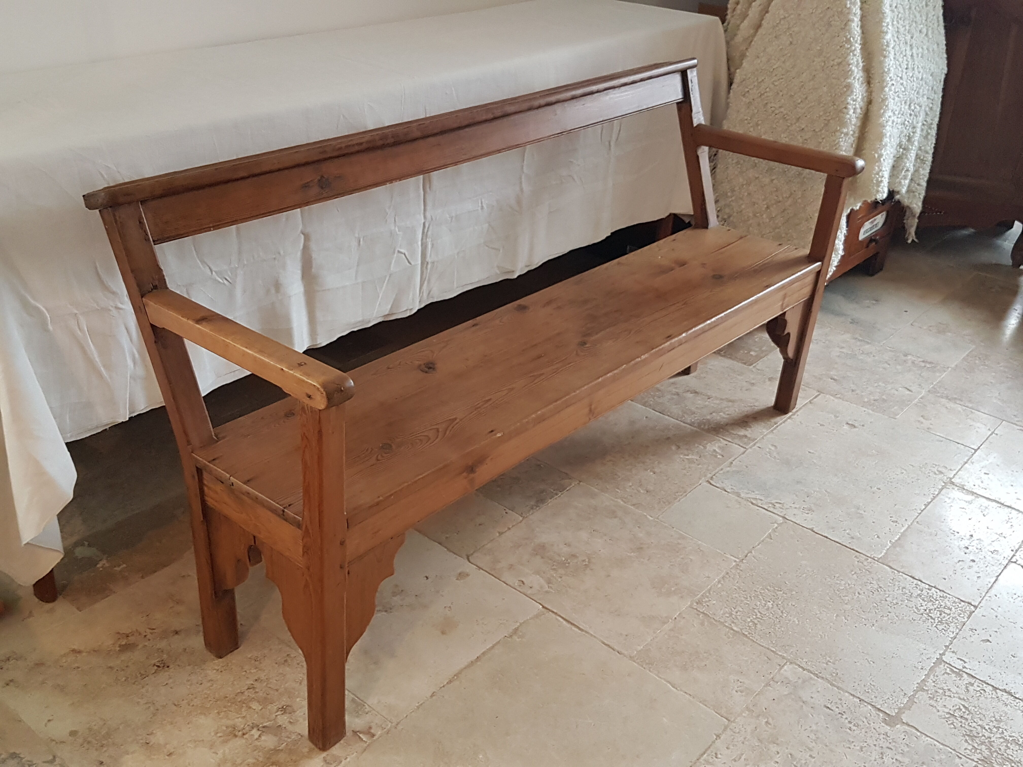 Church bench in fir tree with armrests