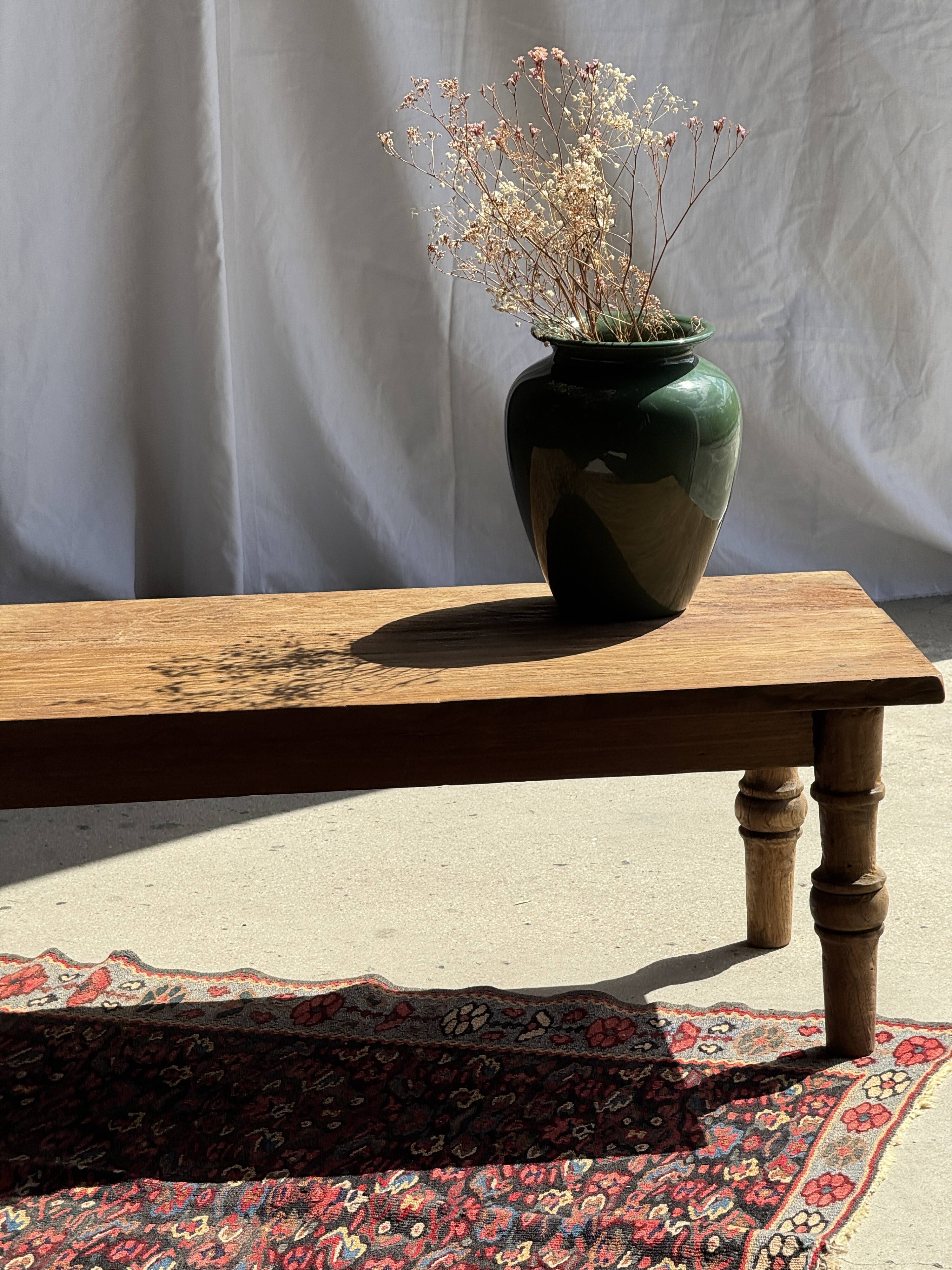 Brown Indonesian teak coffee table, with a border and cylindrical legs H40 L103.