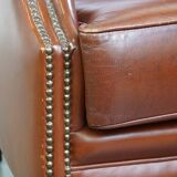 Correct, comfortable, luxurious English-style wingback armchair made of cognac-colored cow leather