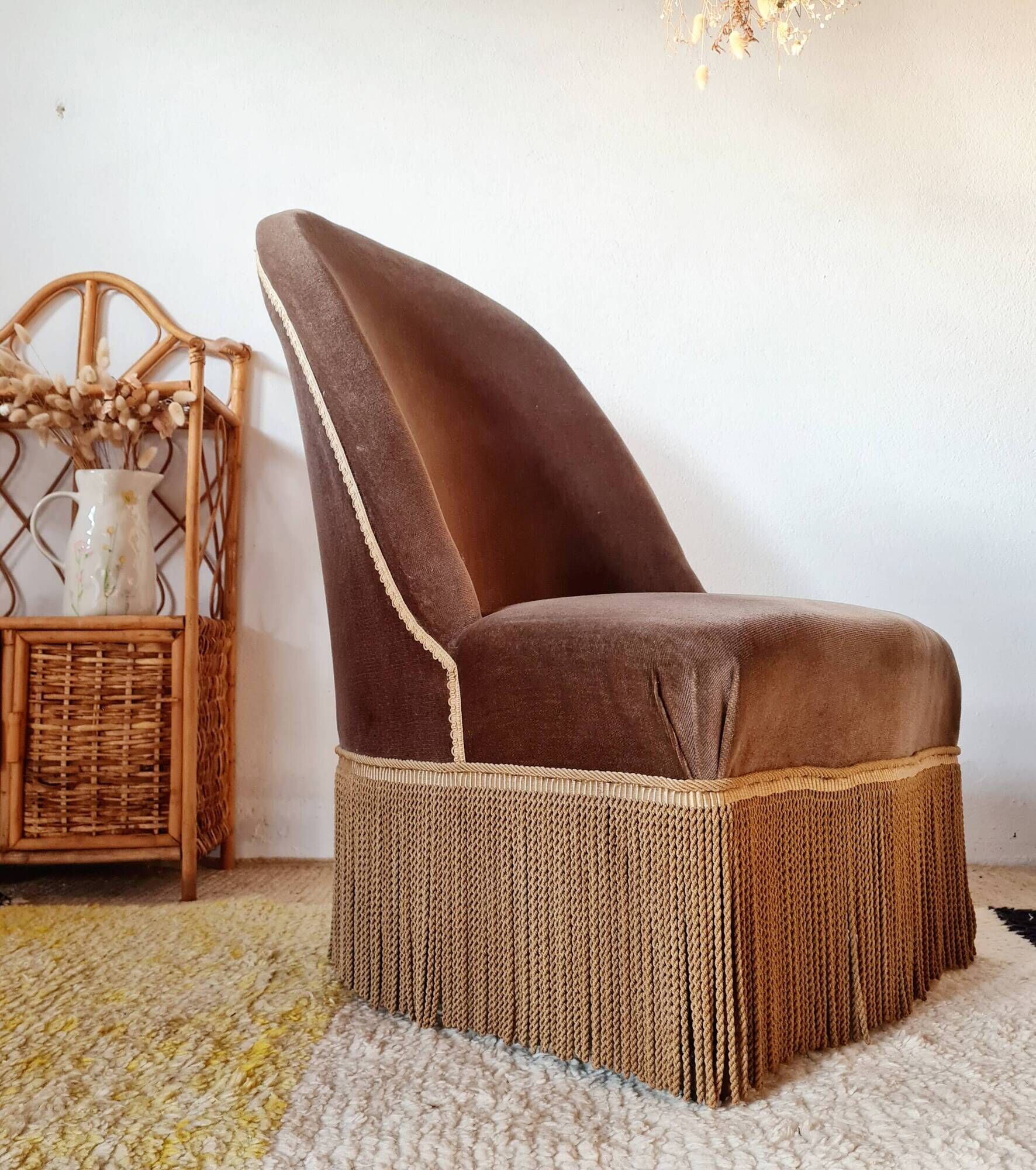 Brown velvet crapaud armchair with fringes and sculpted legs.