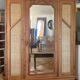 Large antique wardrobe made of solid raw wood and natural caning.