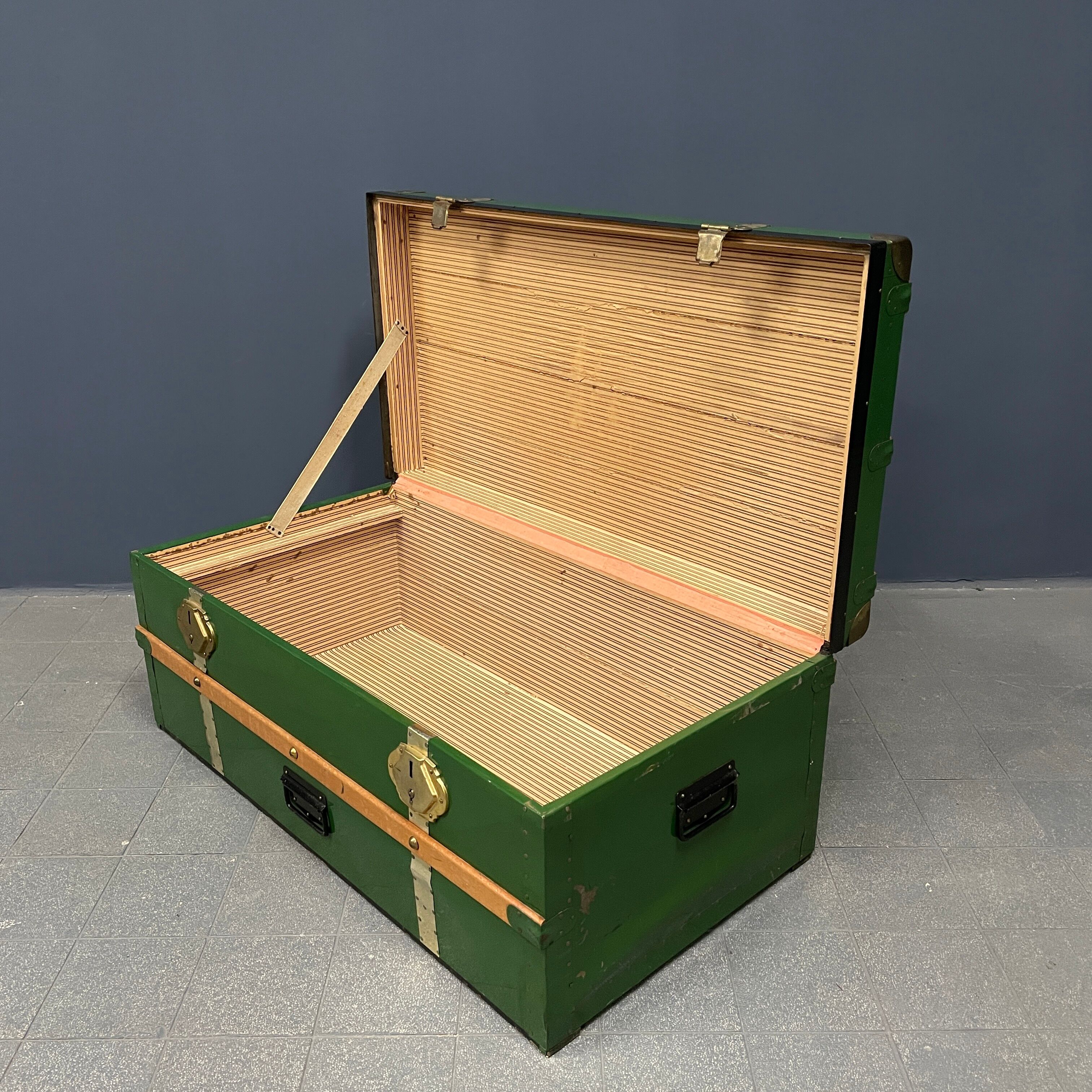 Green metal trunk with wooden sleds