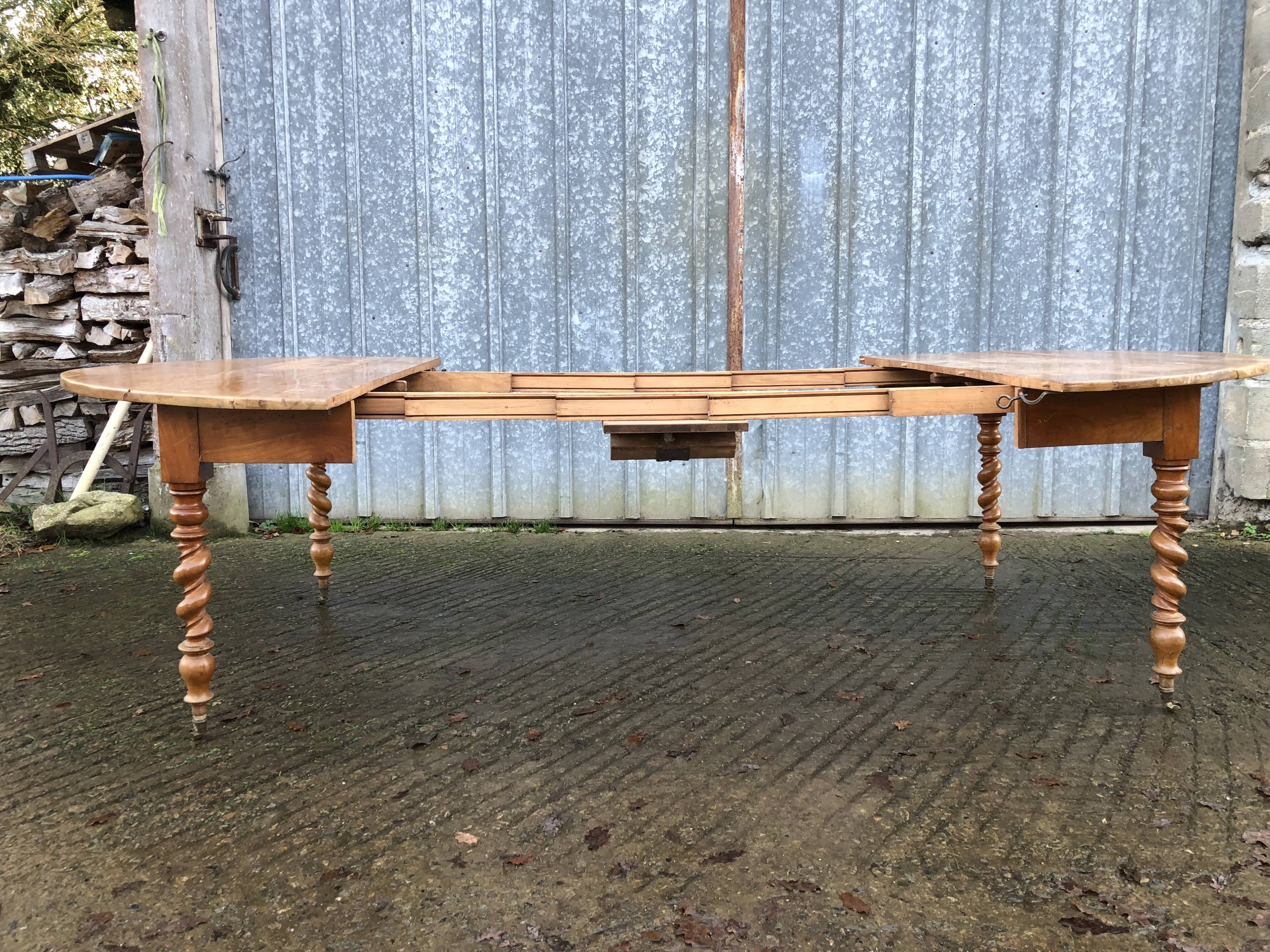 Round table in solid cherry wood, extendable with twisted legs, Louis Philippe style.