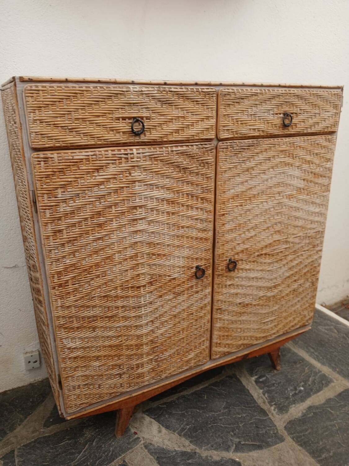 Vintage woven rattan furniture with tapered legs.
