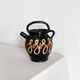 Old vase in glossy black ceramic, vintage exterior decoration.