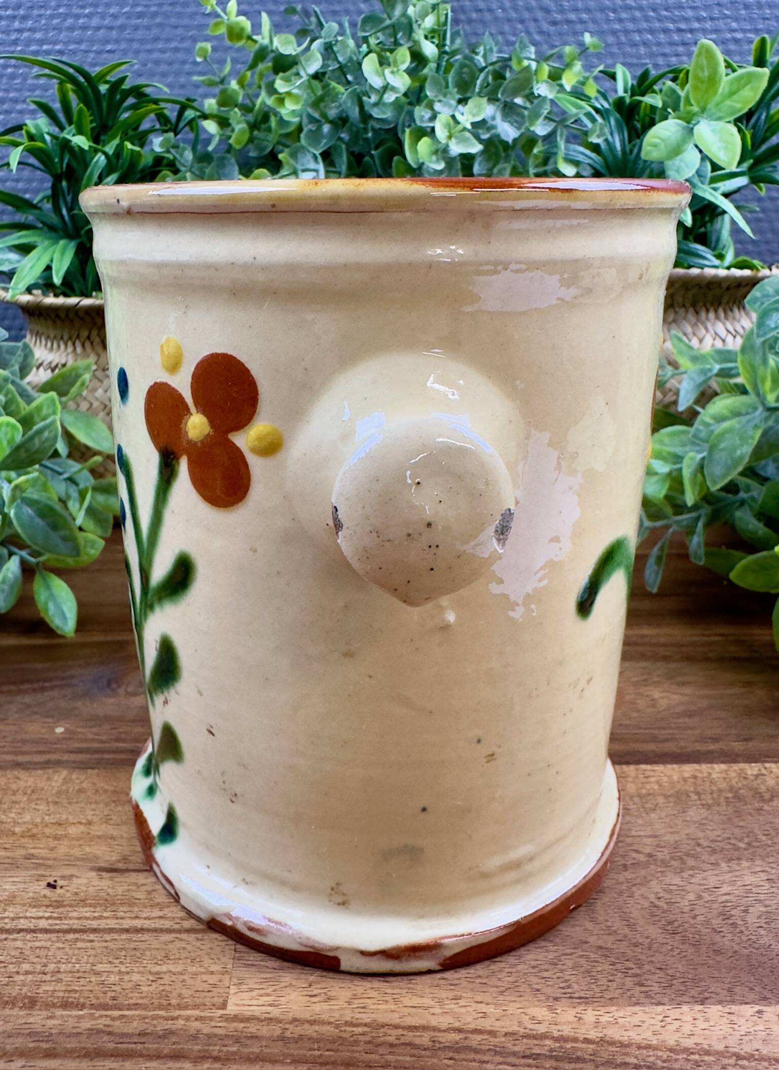 Antique ceramic pot with hand-painted floral decoration.