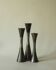 Set of three diabolo-shaped candle holders made of cast steel.