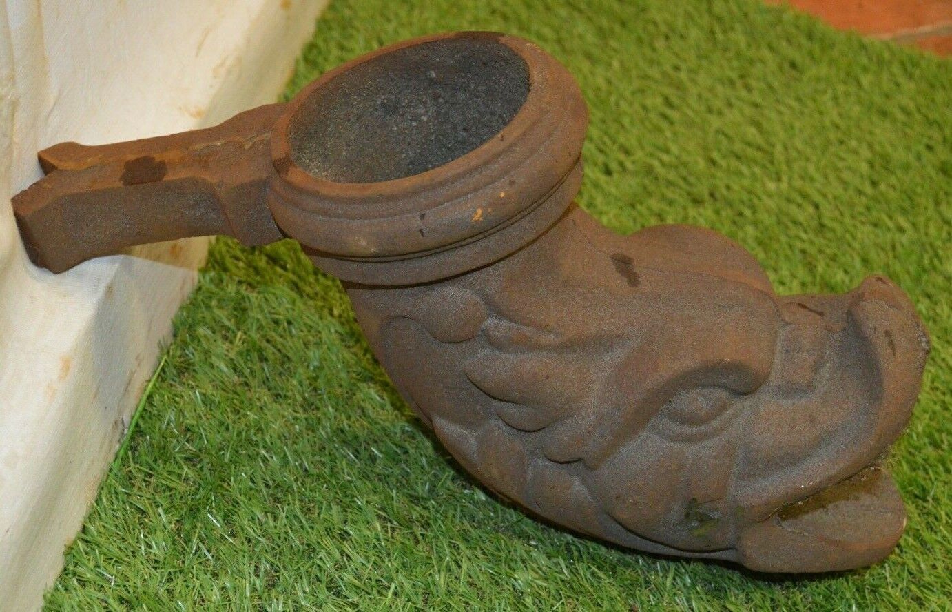 Cast iron gutter downspout in the shape of a dolphin