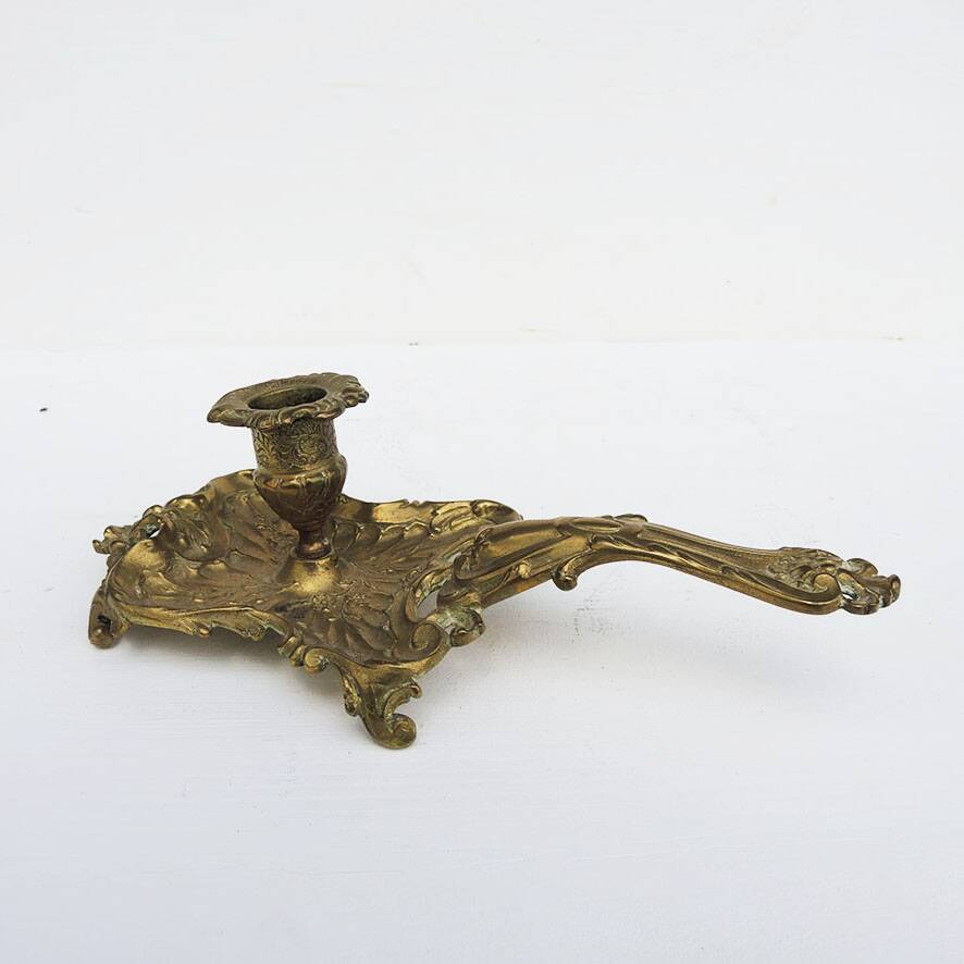 Antique rococo-style hand candlestick in bronze or brass