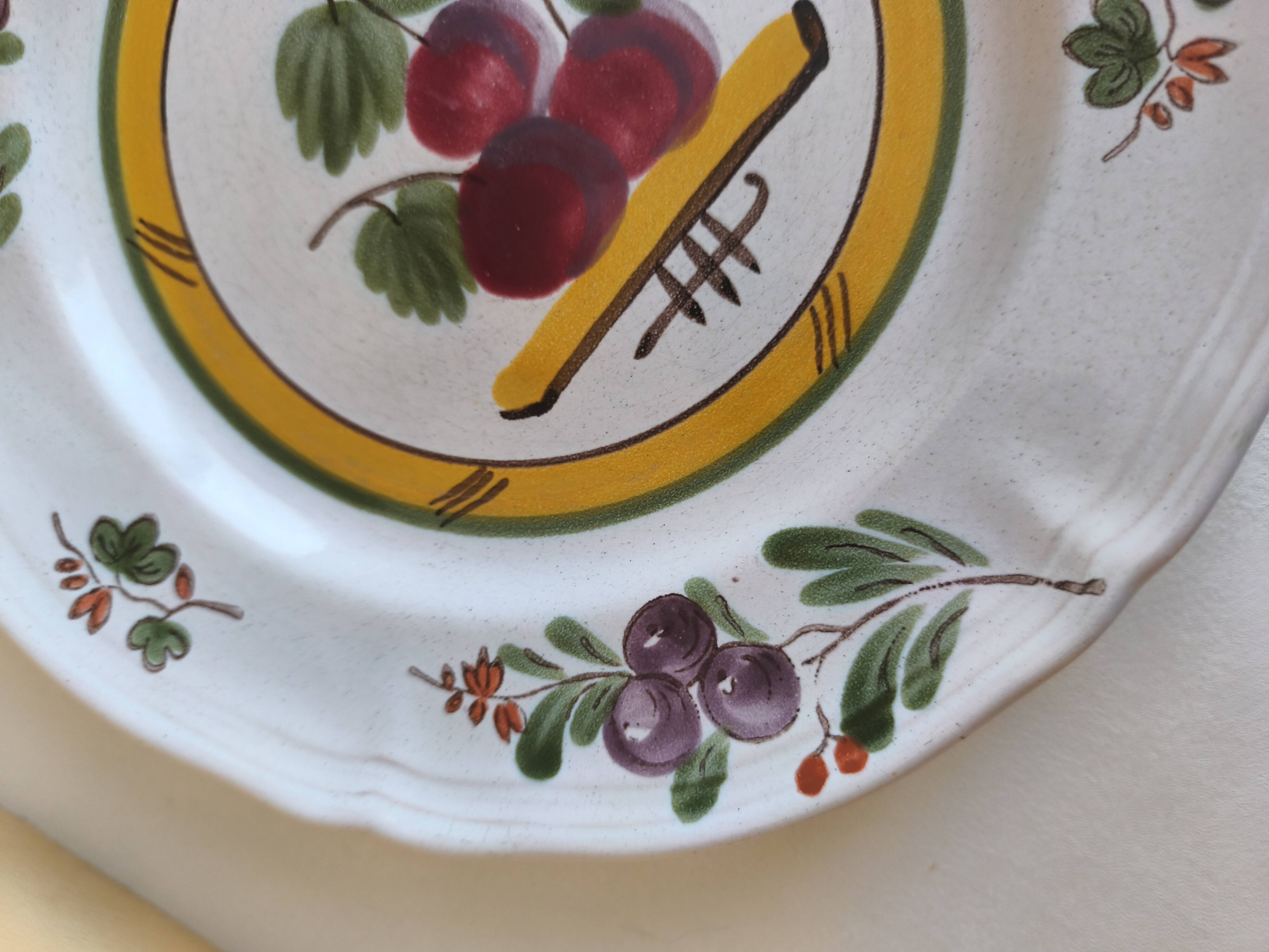 Two earthenware plates with fruits, pears and plums.