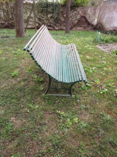 Old metal garden bench with wooden slats