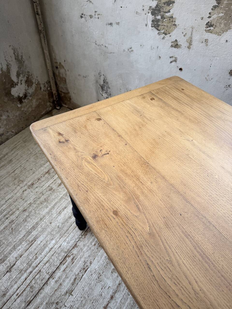 Oak farmhouse table with turned black legs.