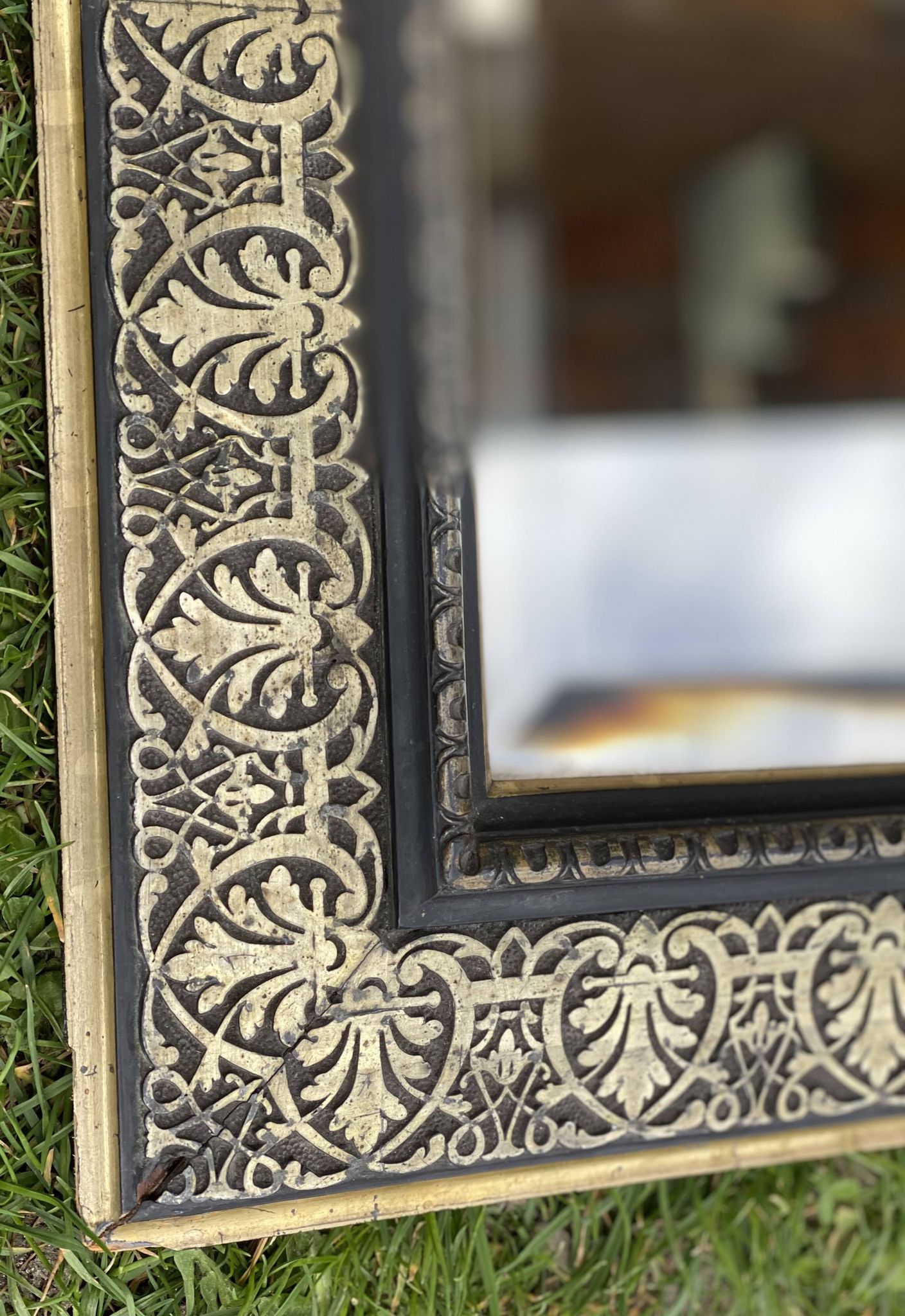 Bevelled mirror from the 19th century with gold and black palmettes.