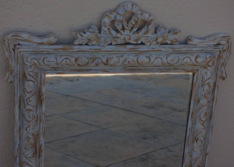 Chic and stylish old mirror with carved wooden frame in limed white and gold